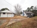 Exterior view showing the house, detached garage, and gravel side yard at 2084 North Rd, Snellville, GA 30078