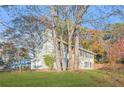 Grey two-story home surrounded by mature trees, offering a serene and private setting at 4704 Keighley Dr, Stone Mountain, GA 30083