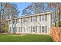 Beautiful two-story home with grey siding, black shutters, and a lush green lawn at 4704 Keighley Dr, Stone Mountain, GA 30083