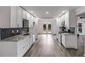 Well-lit kitchen featuring white cabinets, stainless steel appliances, and herringbone backsplash at 2412 Renny Ct, Marietta, GA 30066