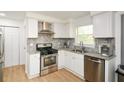 Updated kitchen features granite countertops, stainless steel appliances and sleek white cabinets at 2133 Creekview Trl, Decatur, GA 30035