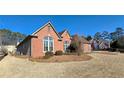 Expansive yard surrounds home with mature trees, well-maintained landscaping and brick exterior at 4875 Gladstone Pkwy, Suwanee, GA 30024