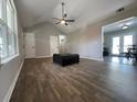 Open living room with sleek flooring, neutral walls, high ceiling and smooth transition to kitchen and dining areas at 28 Fawn Ct, Sharpsburg, GA 30277