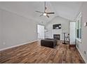 Cozy living room with a fireplace, wood-look flooring, and vaulted ceilings at 28 Fawn Ct, Sharpsburg, GA 30277