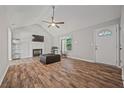 Bright living room featuring a fireplace, vaulted ceiling, and wood-look flooring at 28 Fawn Ct, Sharpsburg, GA 30277