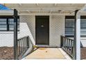 Front porch with a black front door and railing, set against a white brick exterior at 105 Huskins Rd, Canton, GA 30115