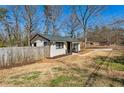 Rear exterior of this cozy home showcasing a fenced yard and a glimpse of the neighborhood at 105 Huskins Rd, Canton, GA 30115