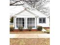 Curb appeal with a screened-in porch, gray-trimmed windows, and attractive landscaping at 5091 Newark Ave, Clarkdale, GA 30111