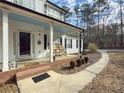 Inviting front porch featuring wood rocking chairs, brick accents, and a light blue ceiling at 815 Lake Stone Lea Dr, Oxford, GA 30054