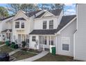 Exterior view of townhomes, each featuring a covered porch and manicured front yard at 5915 Trent Walk Dr, Lithonia, GA 30038