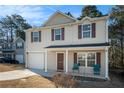 Inviting two-story home featuring a covered front porch and an attached one-car garage at 5987 Westchase St, Atlanta, GA 30336