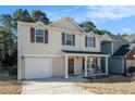 Desirable two-story home boasting a cozy front porch, attached garage and manicured lawn at 5987 Westchase St, Atlanta, GA 30336