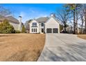 Inviting home exterior featuring a long driveway, spacious lawn, and trees in the front yard at 10780 S Kimball Bridge Xing, Alpharetta, GA 30022