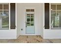 Charming light blue front door with glass panels, framed by dark shutters and stone flooring at 112 Dallas Mark Drive, Canton, GA 30115