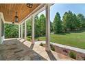 Inviting covered porch with stone flooring, wood ceiling and view of the lush green lawn at 112 Dallas Mark Drive, Canton, GA 30115