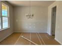 Bright dining room with large window and elegant chandelier, ready for your personal touch at 385 Riverwood Pass, Dallas, GA 30157