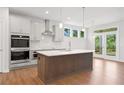 Modern kitchen with stainless appliances, an island, and wood flooring at 385 Riverwood Pass, Dallas, GA 30157