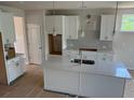 Modern kitchen with white cabinets, quartz countertops, and a spacious center island at 385 Riverwood Pass, Dallas, GA 30157