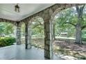 Covered porch featuring arched columns with a view of the landscaped yard at 1110 Asbury St, Oxford, GA 30054