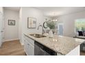Kitchen island features a sink, stainless steel dishwasher, and granite countertops for ample cooking space at 228 Epping Street # 8, Stockbridge, GA 30281