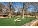 Backyard retreat offers a lovely table set amongst the trees at 4983 Arcado Sw Rd, Lilburn, GA 30047