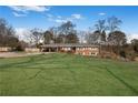 Sprawling front lawn accentuates this charming brick home at 4983 Arcado Sw Rd, Lilburn, GA 30047