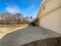 Spacious driveway leading to a two-car garage on a traditional-style home with mature trees at 5926 Brassie Ridge Ln, Ellenwood, GA 30294