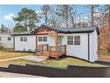 Well-maintained white brick home featuring a charming front porch and manicured lawn at 5901 Miller Rd, Austell, GA 30106
