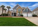 Beautiful two-story home with a stone accent, a lush green lawn, and an attached two-car garage at 820 Nob Ridge Dr, Marietta, GA 30064