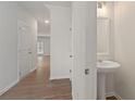 Clean foyer features wood floors, white walls, and a pedestal sink at 7016 Fringe Flower Dr # 88, Austell, GA 30168