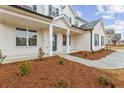 Inviting front porch with painted brick, columns, tasteful landscaping, and a charming entrance into this lovely home at 801 Dobby Way (Lot 92), Mcdonough, GA 30252