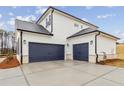 Spacious two-car garage with blue doors and a well-finished concrete driveway, offering ample parking space at 801 Dobby Way (Lot 92), Mcdonough, GA 30252