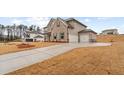 Long driveway leading to a two-car garage, set against a backdrop of meticulously maintained lawn at 805 Dobby Way (Lot 93), Mcdonough, GA 30252