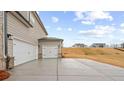 Side view of a two-car garage with a concrete driveway extending to the road at 805 Dobby Way (Lot 93), Mcdonough, GA 30252