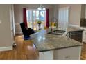 Bright eat-in kitchen island with granite countertops, stainless steel appliances, and a cozy breakfast nook at 2860 Pine St, Duluth, GA 30096