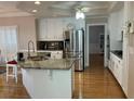 Bright kitchen features granite counters, an island and stainless steel appliances at 2860 Pine St, Duluth, GA 30096