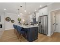 Modern kitchen with large island, pendant lighting, stainless steel appliances, and tile backsplash at 4521 Twinberry Dr, Powder Springs, GA 30127