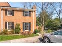 Side view of a brick townhome featuring dark shutters and a well-manicured landscape at 19 Lullwater Ne Pl, Atlanta, GA 30307