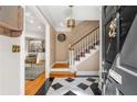 Inviting foyer features a black and white checkered tile floor and staircase with carpet runner at 19 Lullwater Ne Pl, Atlanta, GA 30307