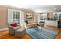 Bright living room with hardwood floors, built-in shelving, and large windows with shutters at 19 Lullwater Ne Pl, Atlanta, GA 30307