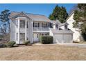 Traditional home with a small porch, dormer windows, and a two-car garage at 613 Lone Oak Dr, Lithonia, GA 30058