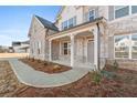 Inviting front porch featuring stone accents and a stylish gray front door at 800 Dobby Way (Lot 104), Mcdonough, GA 30252