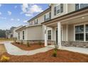 Welcoming front entrance with a covered porch and brick accents, offering a charming and inviting curb appeal at 267 Arwen Drive (Lot 66), Mcdonough, GA 30252