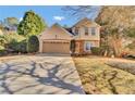 Charming two-story home with a well-manicured lawn, mature trees and a long driveway to a 2-car garage at 267 Windy Cir, Mcdonough, GA 30253