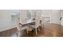 Elegant dining room with hardwood floors, wainscoting, and modern upholstered chairs at 4344 Colorado Fir Aly, Doraville, GA 30360