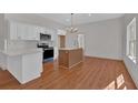 Modern kitchen with white cabinets, stainless steel appliances, and a center island at 436 Tarpley Ave, Bowdon, GA 30108