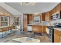 Well-lit kitchen with stainless steel appliances, wood cabinets and stone tile floors at 920 Pine Grove Pointe Dr, Roswell, GA 30075
