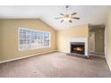 Inviting living room with a cozy fireplace, vaulted ceiling, and a large window at 2901 Soapstone Ct, Powder Springs, GA 30127