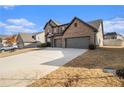 Angle view of a two-story brick home showing the driveway and manicured lawn at 263 Osier Dr, Mcdonough, GA 30252