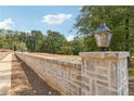 Stone wall with stylish lighting fixtures line the street, enhancing the property's curb appeal at 4525 Muskogee Ct, Cumming, GA 30040